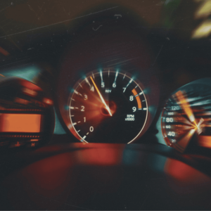 Car dashboard displaying a speedometer and warning lights, related to an online speed awareness course.