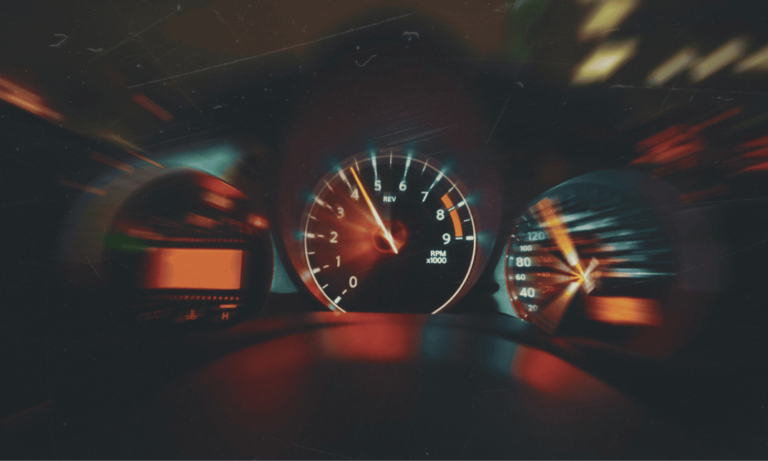 Car dashboard displaying a speedometer and warning lights, related to an online speed awareness course.